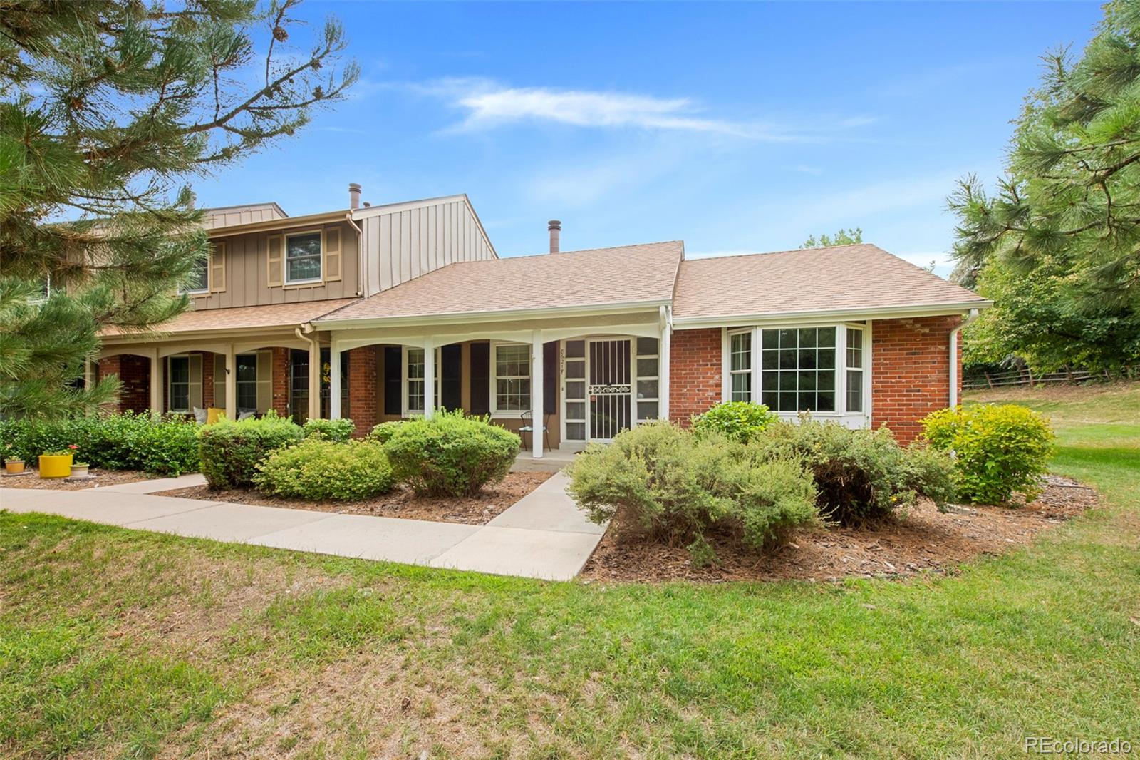 a front view of a house with yard and green space