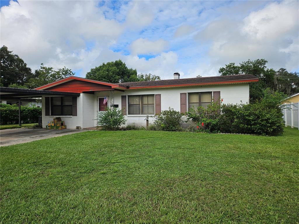 a view of a house with a yard and sitting area