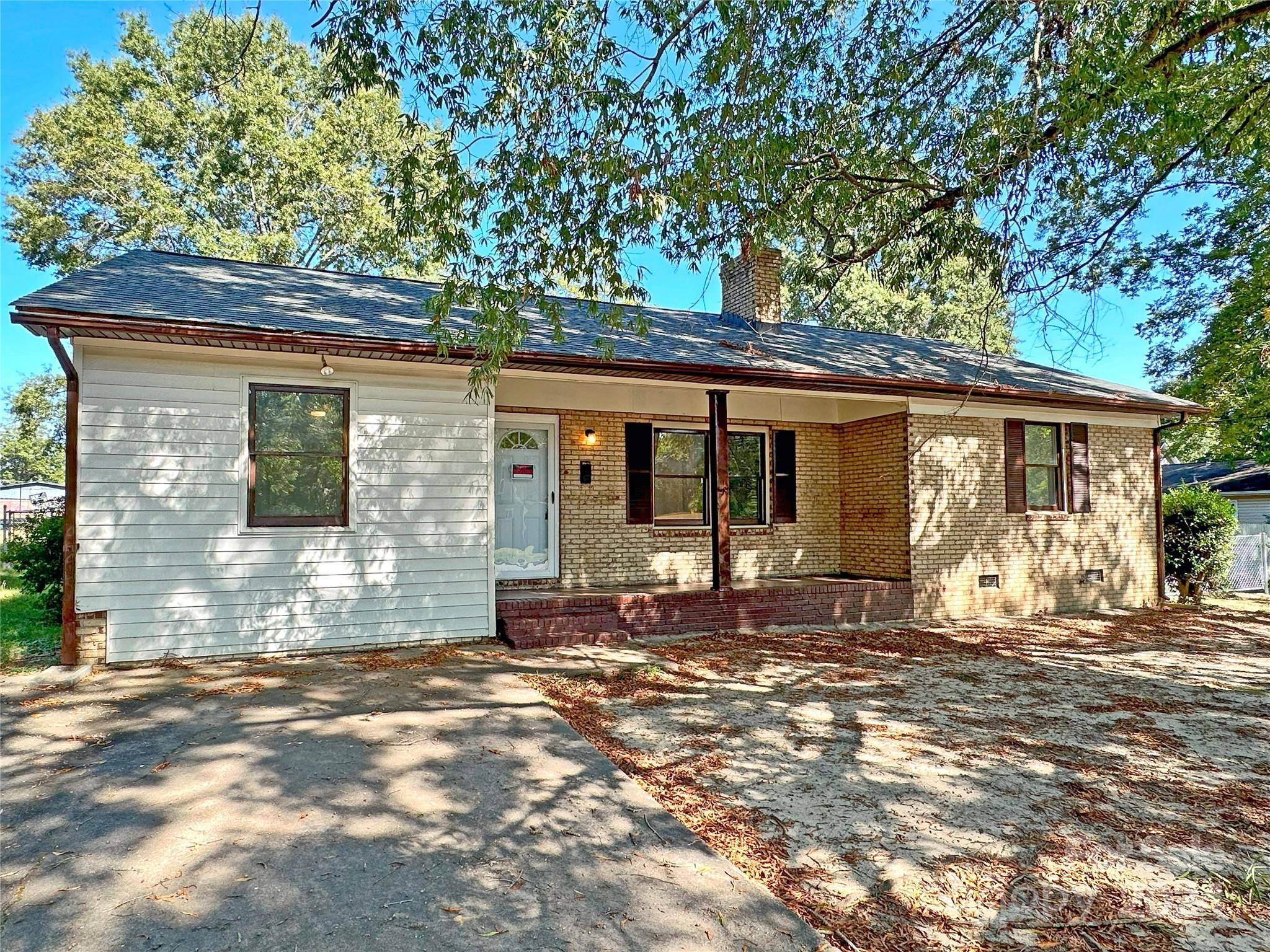 a front view of a house with a large tree