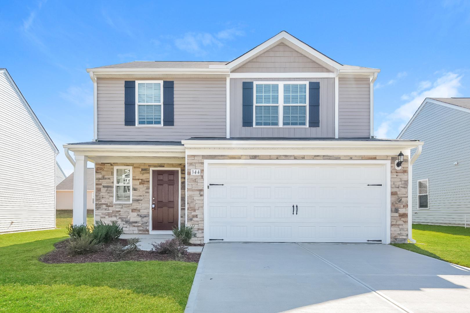 a front view of a house with a yard and a garage