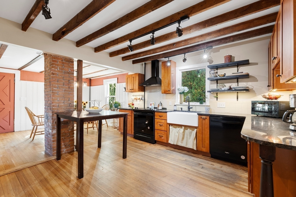 a kitchen with stainless steel appliances granite countertop a stove and a wooden floors