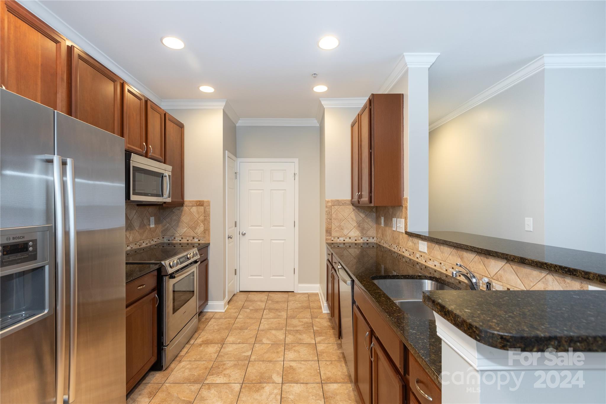 a kitchen with stainless steel appliances granite countertop a refrigerator and a stove