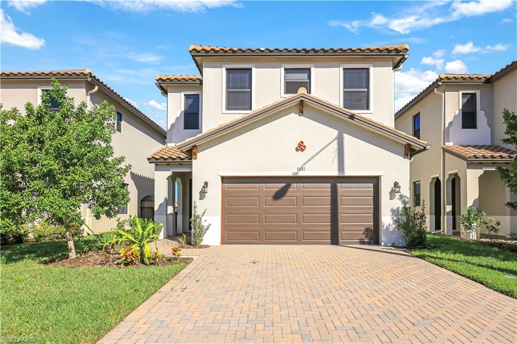 Mediterranean / spanish-style home featuring a garage and a front yard