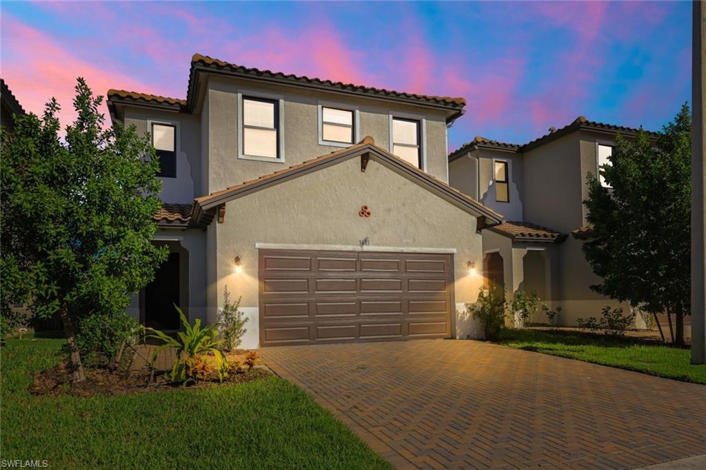 a front view of a house with a yard and garage