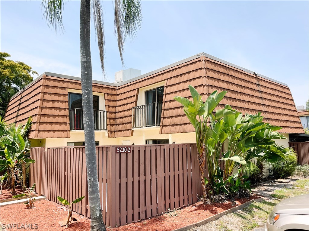 a front view of a house with a yard and potted plants