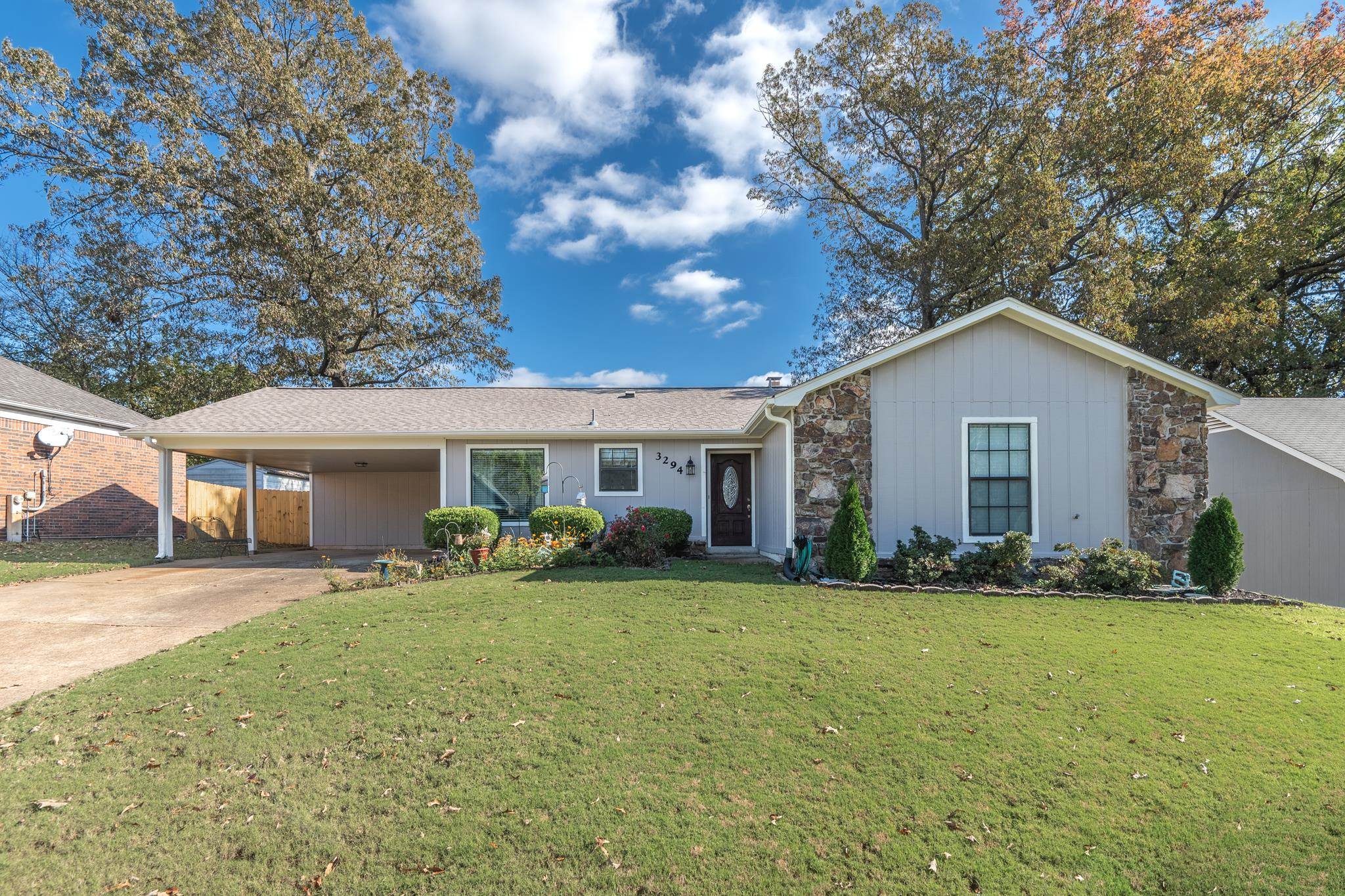 Single story home with a front yard and a carport