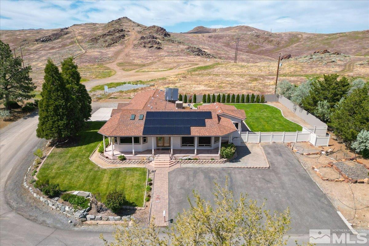 an aerial view of a house with a garden and lake view