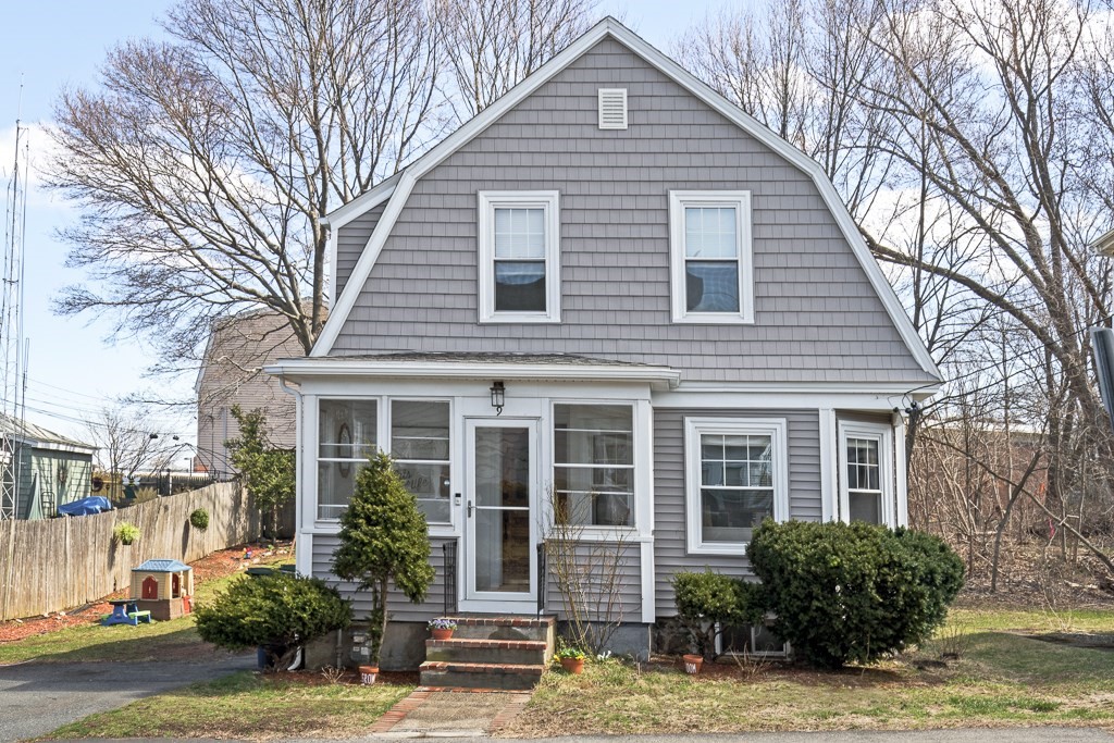 a view of a house with a yard and potted plants