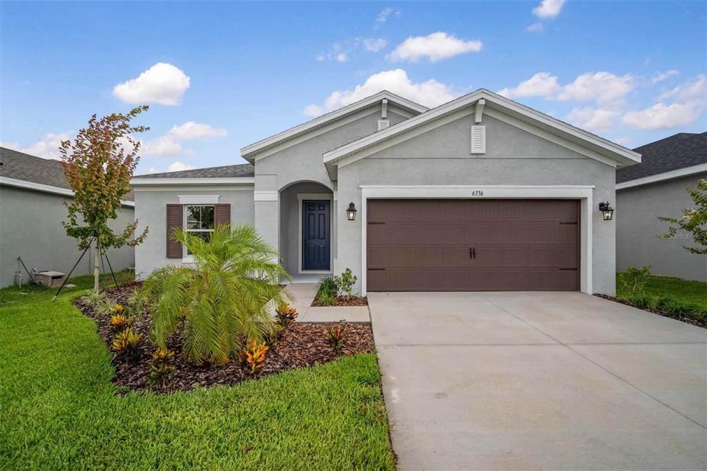 a front view of a house with a yard and garage