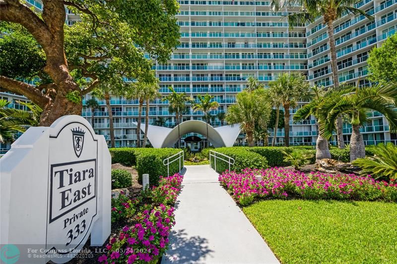 a front view of a building with garden and flowers