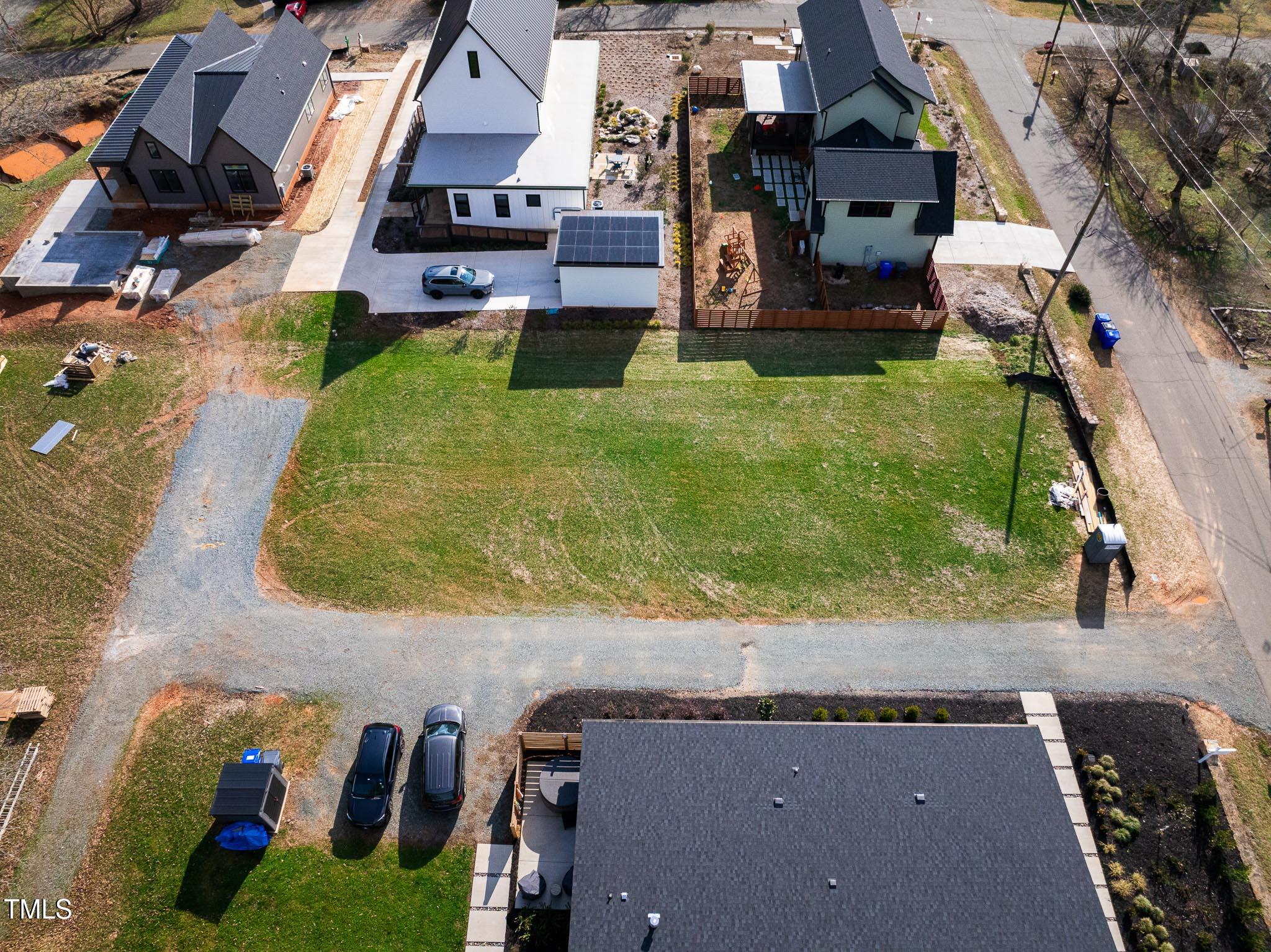 an aerial view of residential houses with outdoor space and parking