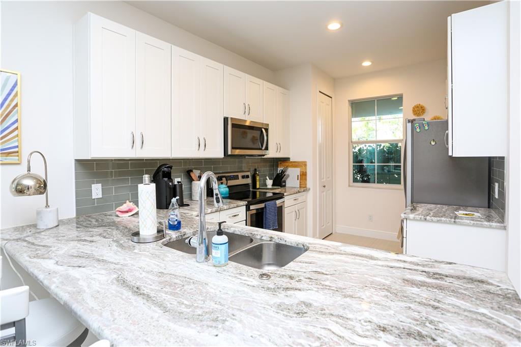 a kitchen with stainless steel appliances kitchen island granite countertop a refrigerator and microwave