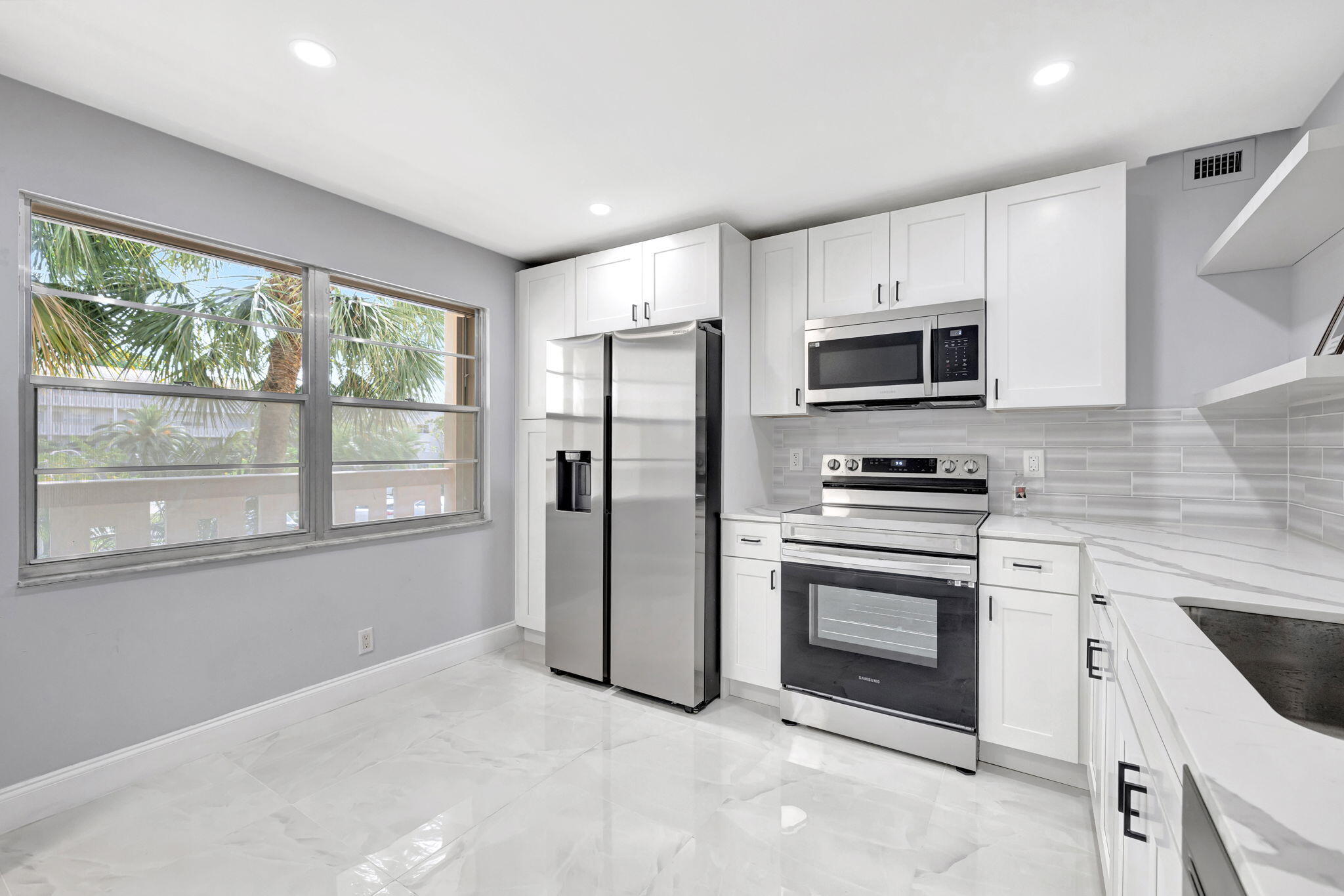 a kitchen with stainless steel appliances a stove sink and microwave