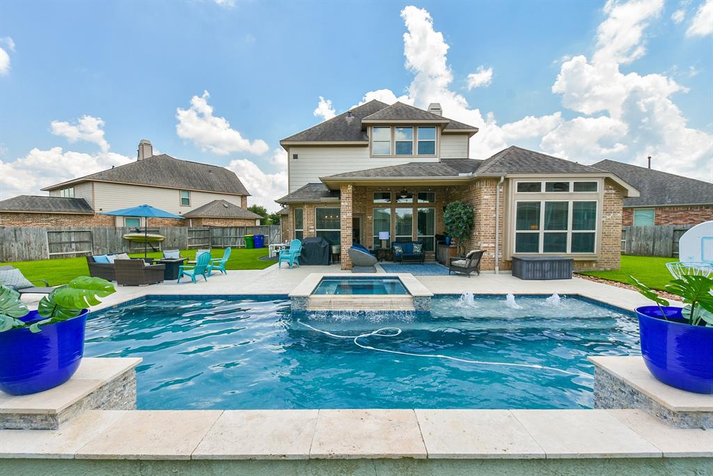 a swimming pool view with a seating space and a garden