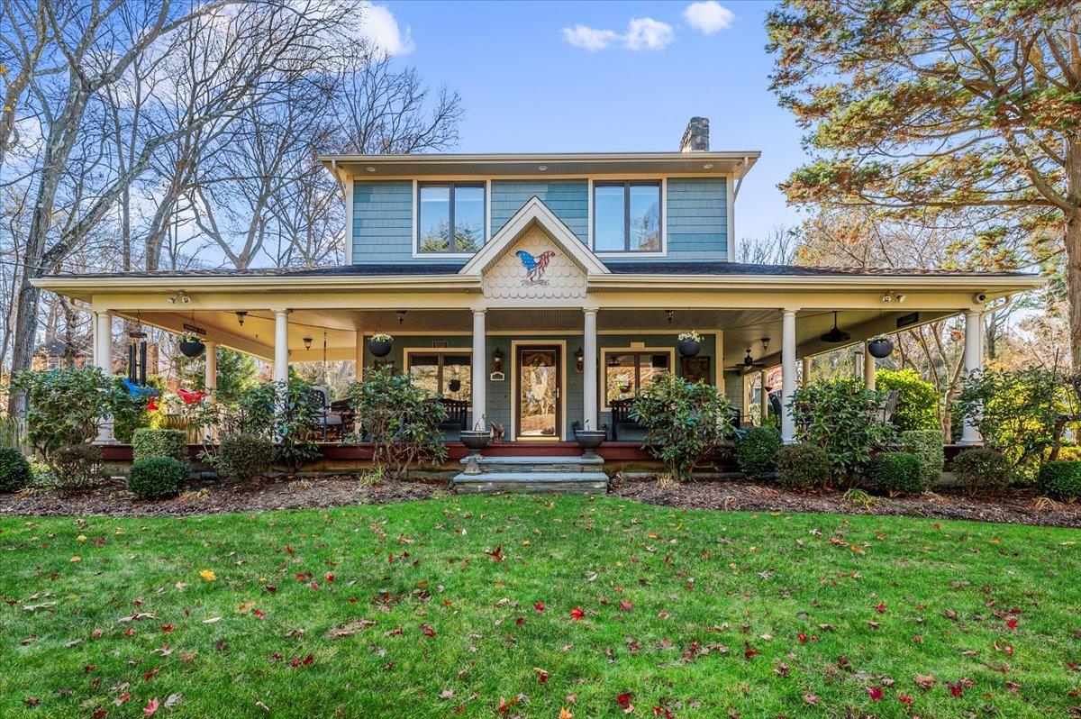 View of front of property featuring a front yard and covered porch