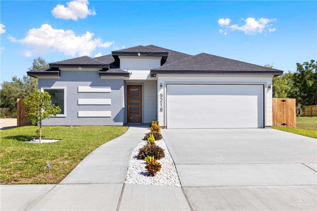 Prairie-style house featuring a front lawn and a garage