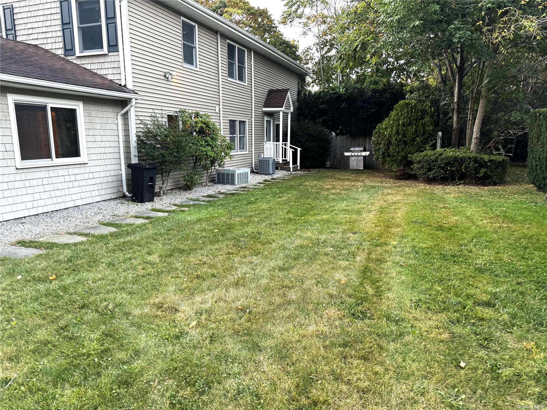 a view of a house with backyard and a tree