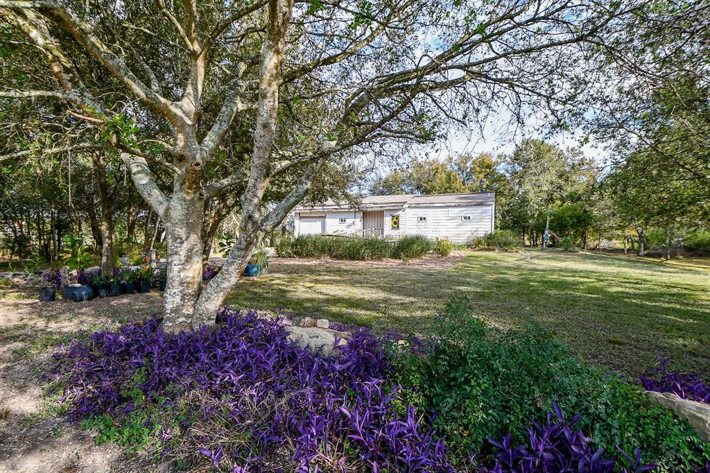 a view of a house with a big yard and large trees