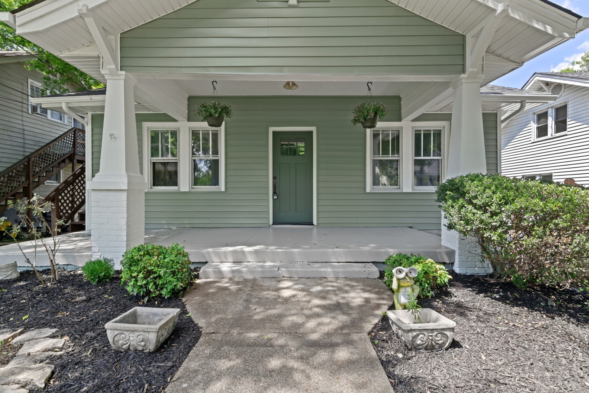 a view of a house with a yard and potted plants