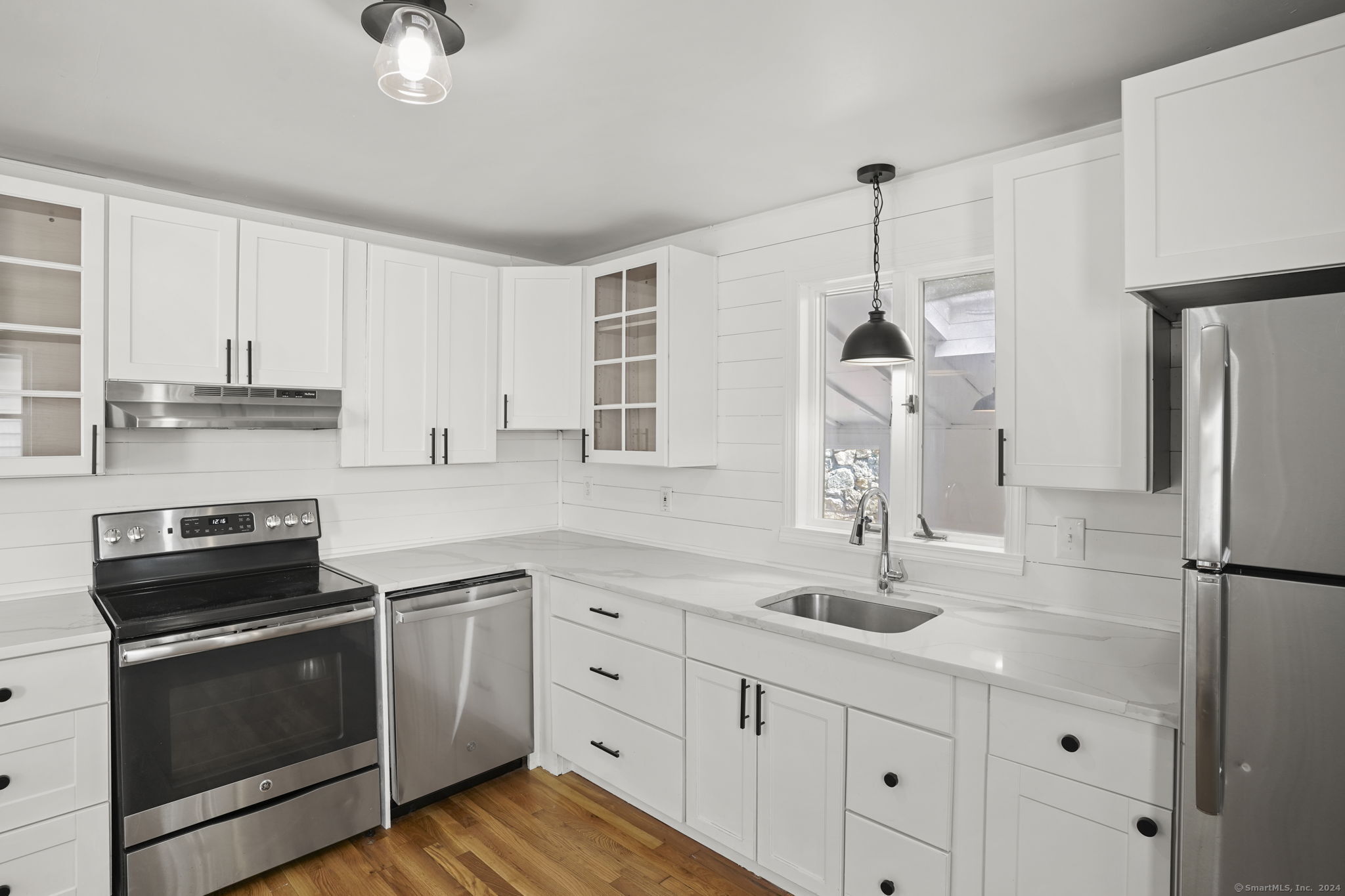 a kitchen with appliances a sink cabinets and wooden floor