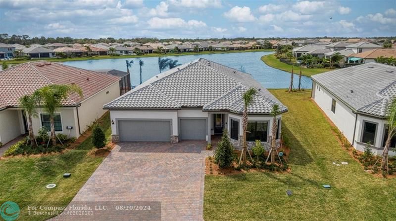 an aerial view of a house with a yard and lake view