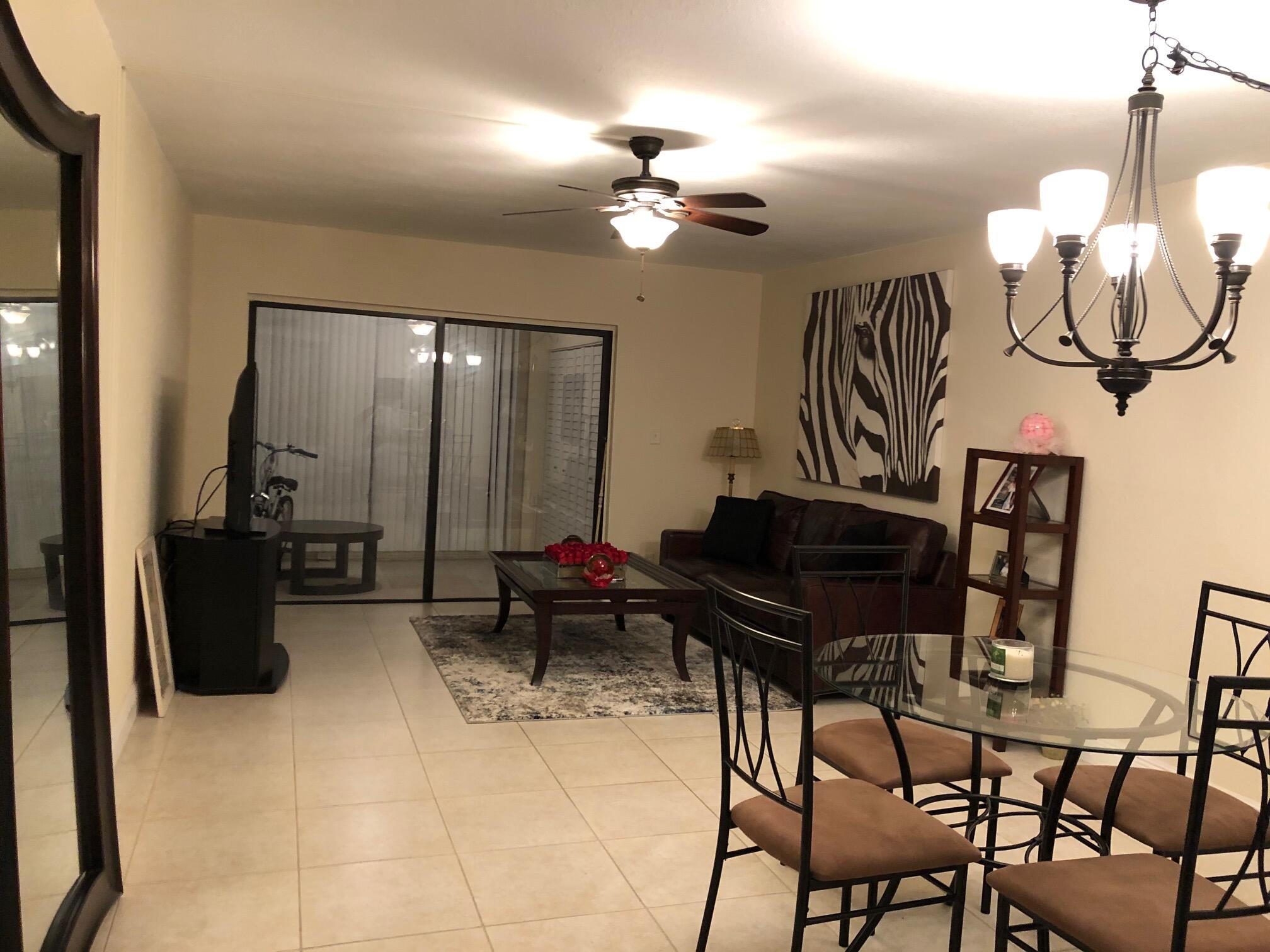 a living room with furniture a piano and a chandelier