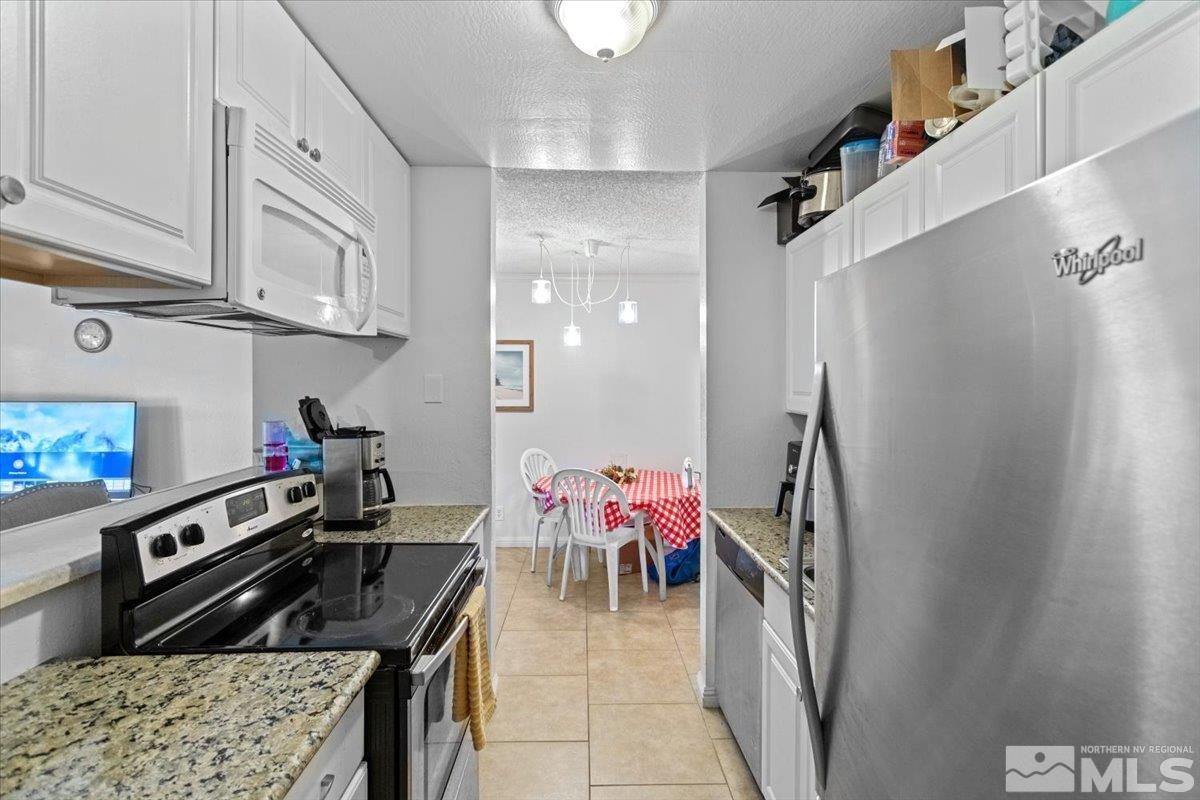 a kitchen with stainless steel appliances granite countertop a refrigerator and a stove