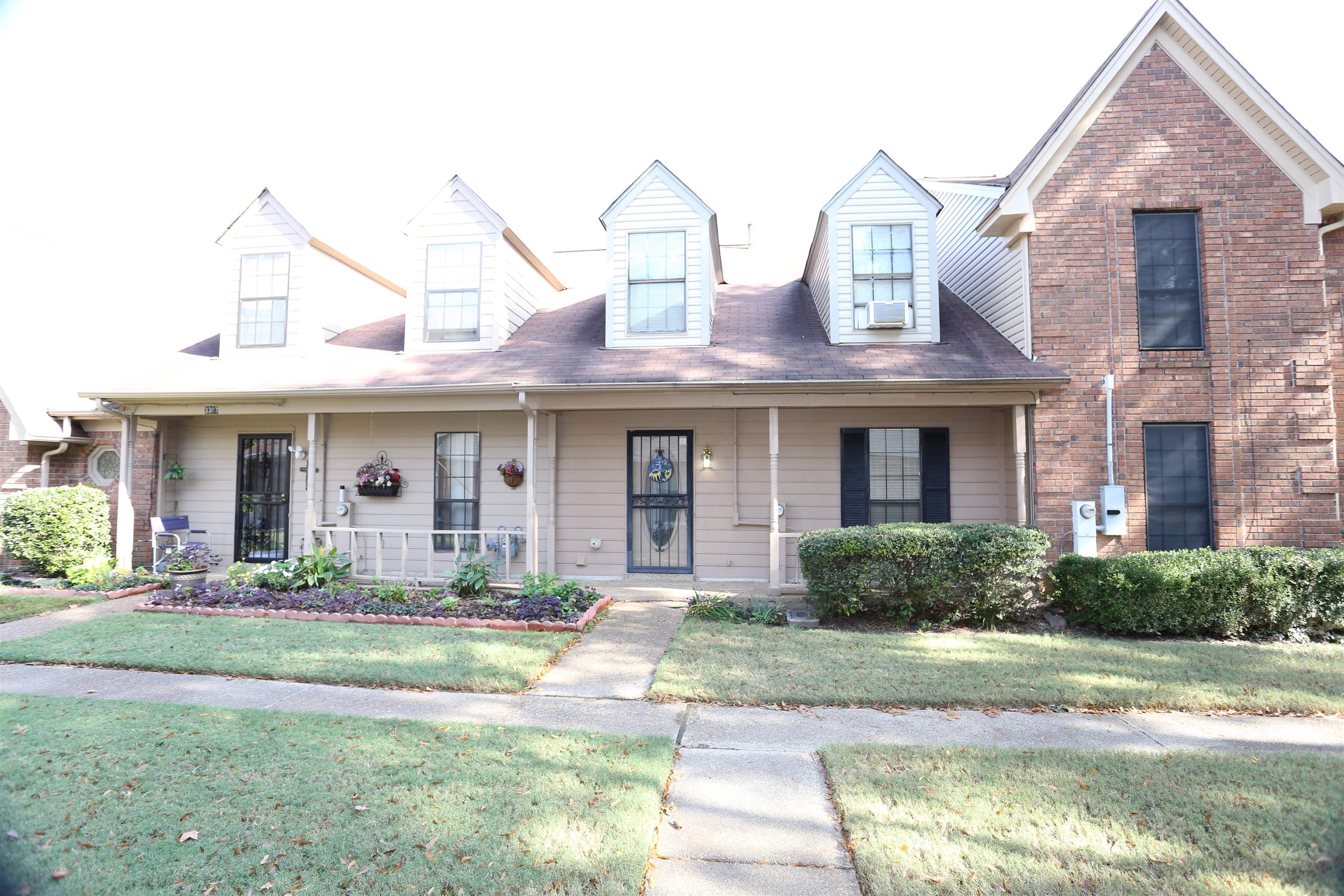 a front view of a brick house with a yard