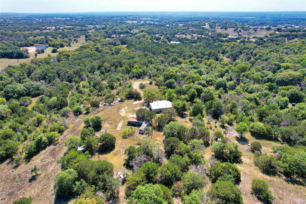 an aerial view of a houses with a lush green hillside