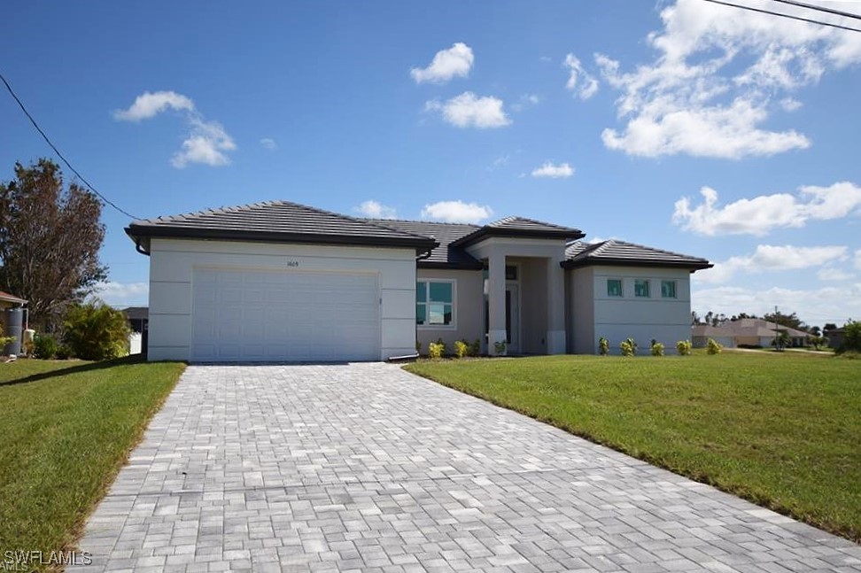 a front view of a house with a garden and yard