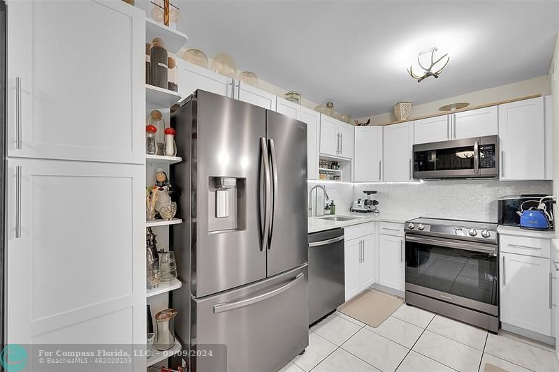 a kitchen with stainless steel appliances granite countertop a refrigerator sink and stove