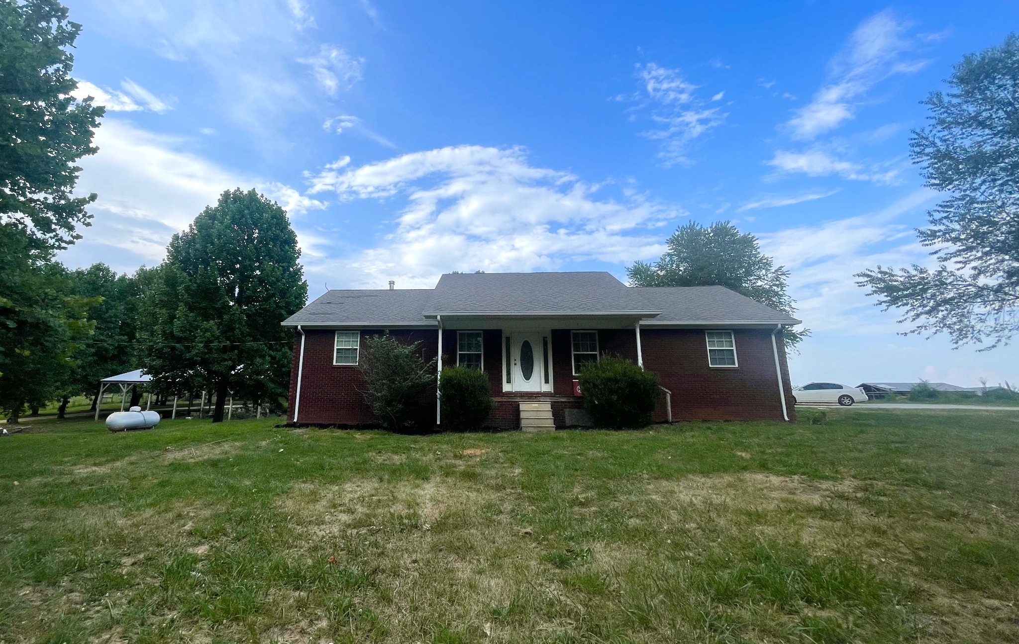 a view of house with yard and front view of a house