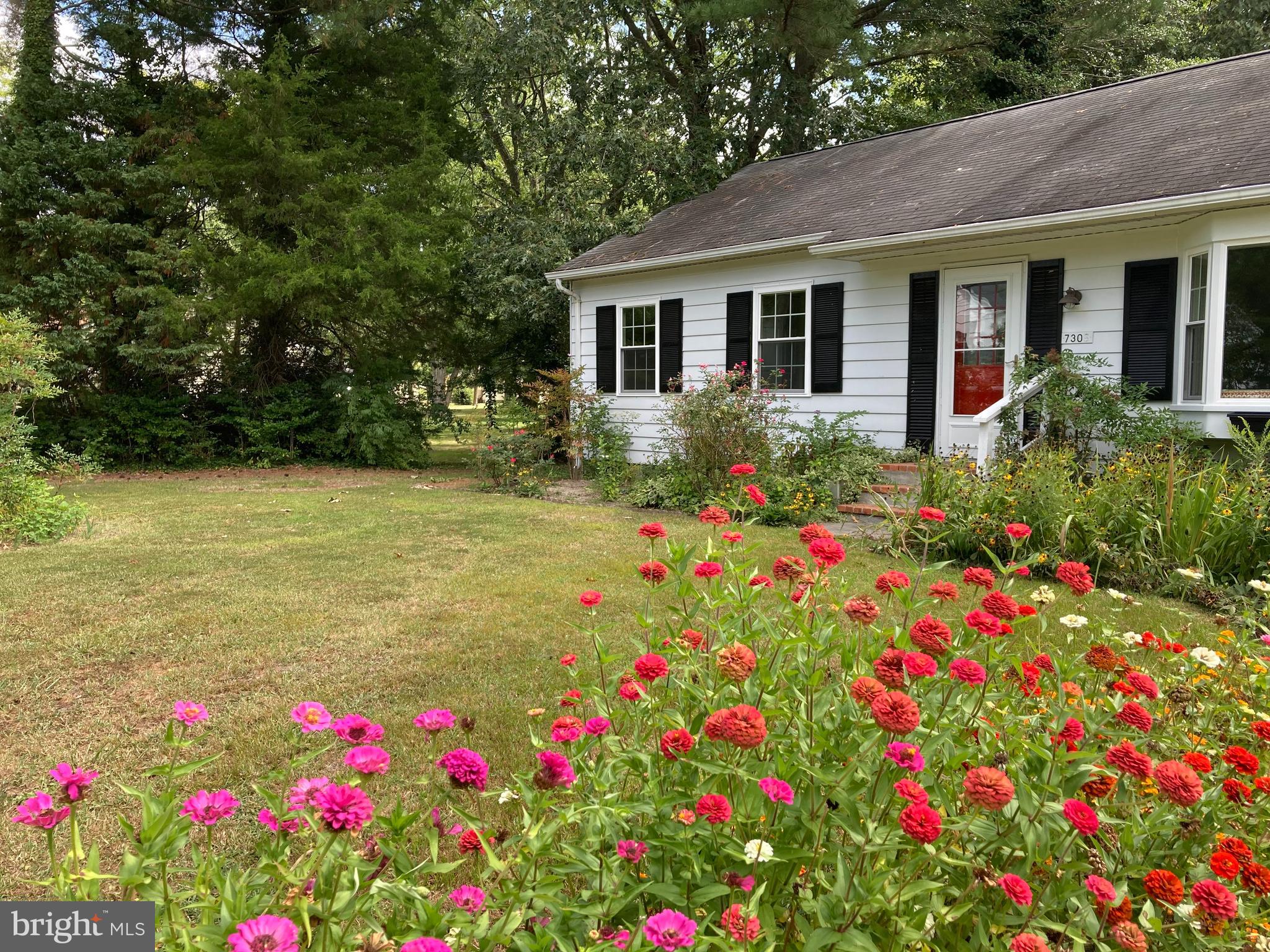 a flower garden in front of a house