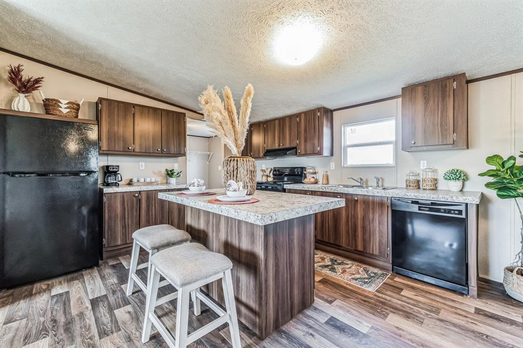 a kitchen with a sink refrigerator and a wooden cabinets