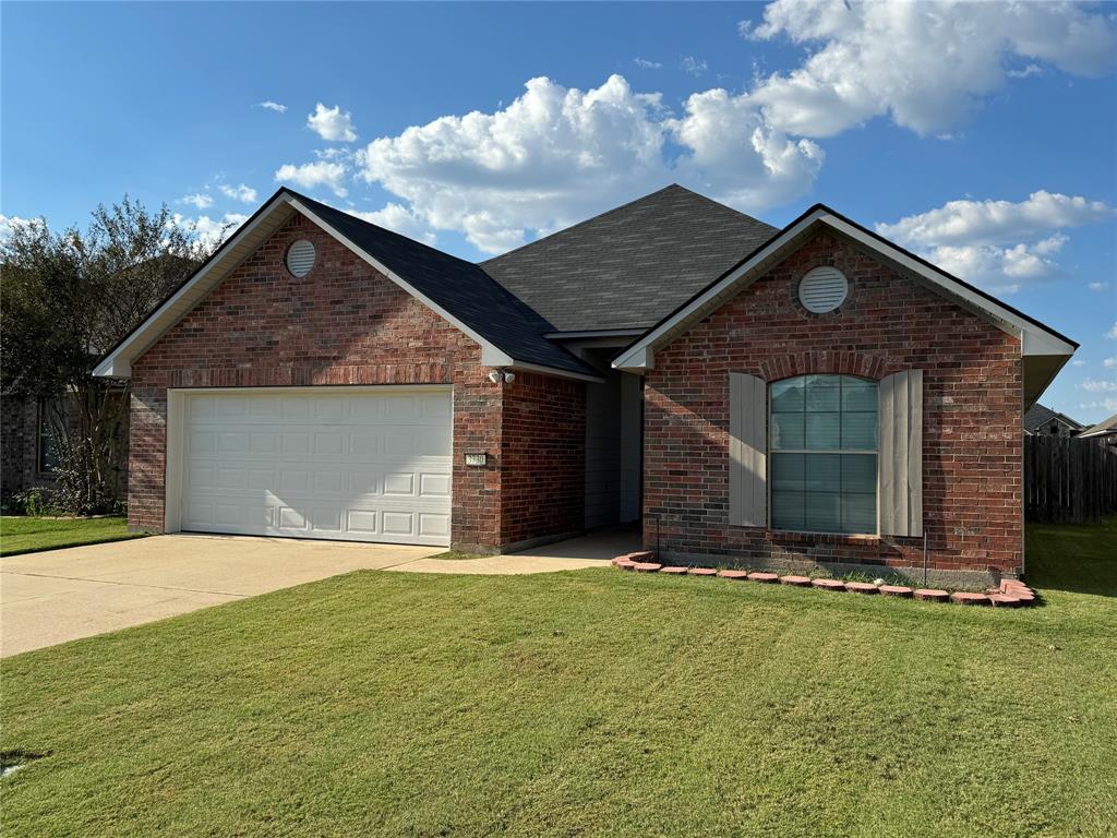 a front view of a house with yard and garage