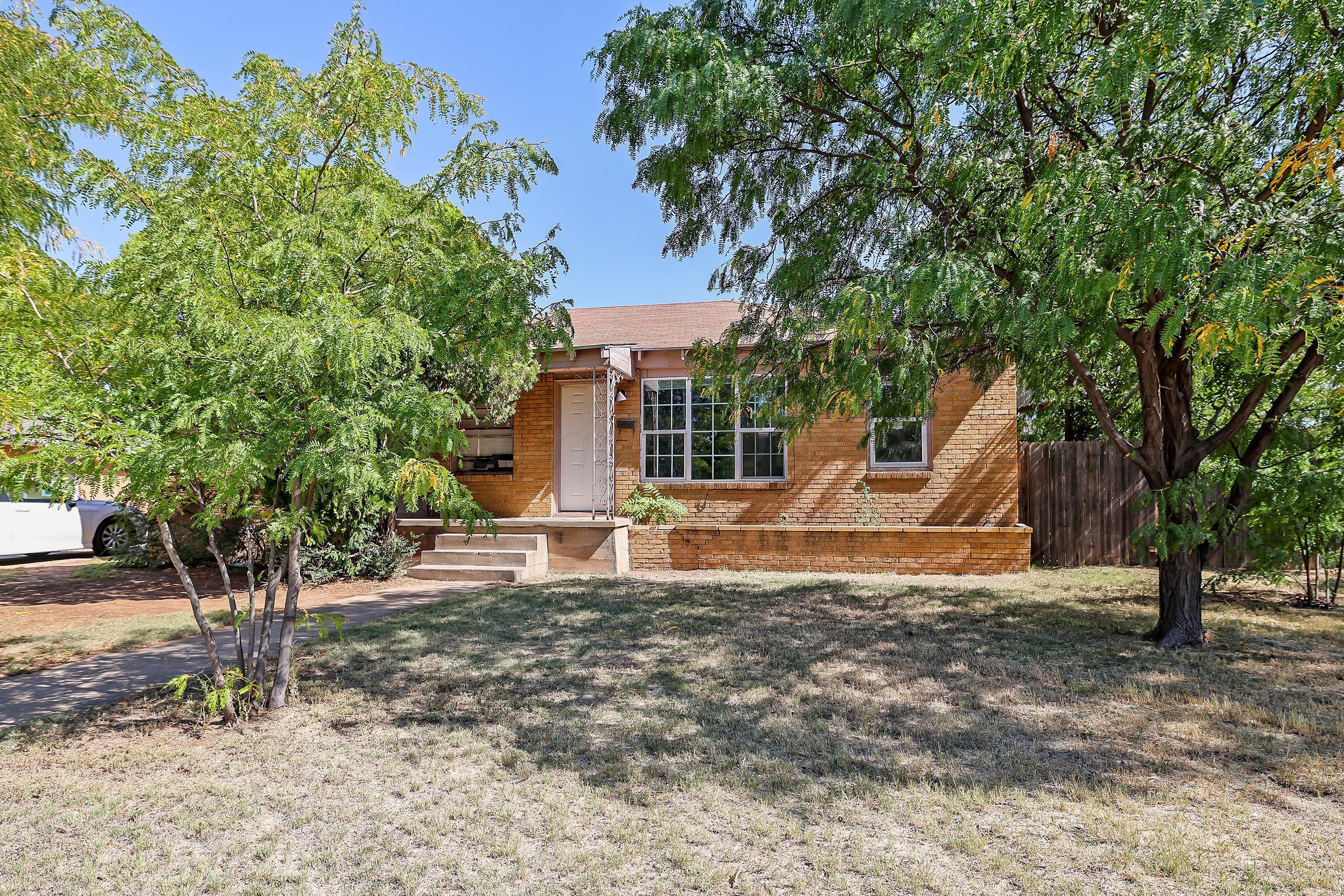 a view of a house with backyard and a tree