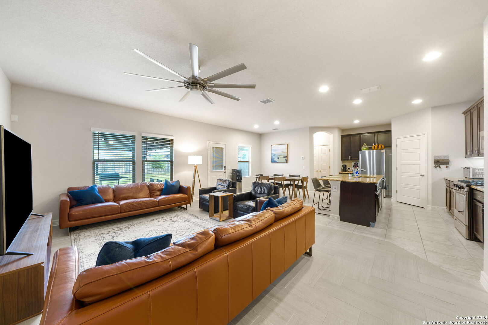 a living room with furniture ceiling fan and a flat screen tv