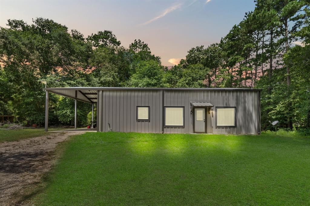 a view of a house with a yard and a large tree