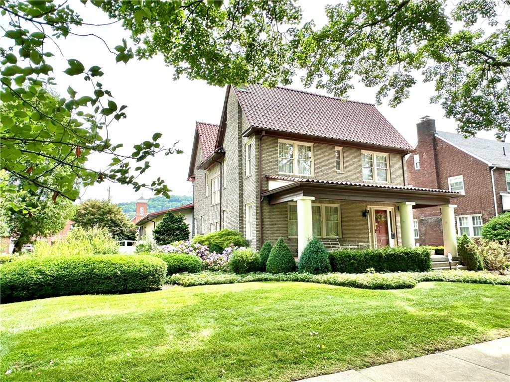 a front view of a house with a yard and potted plants