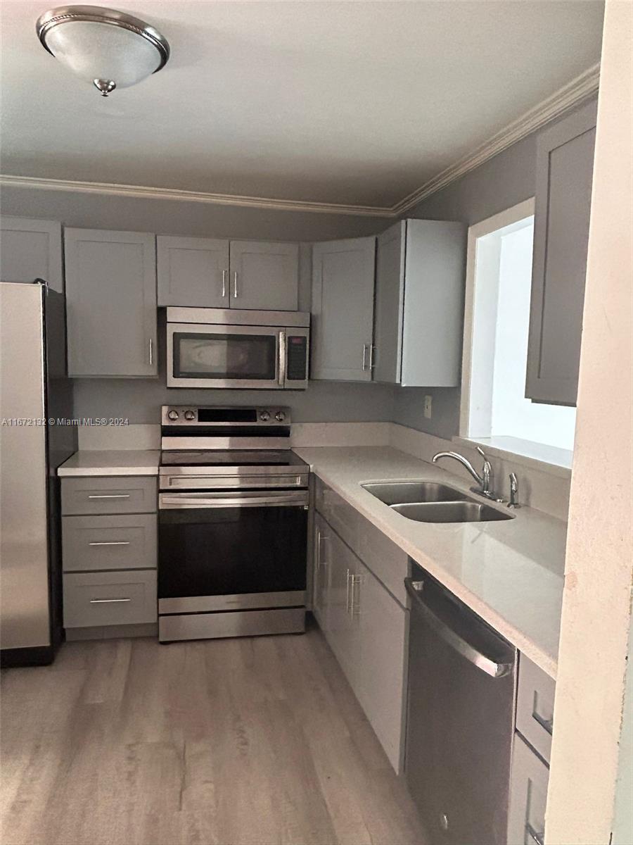 a kitchen with granite countertop a sink and stainless steel appliances