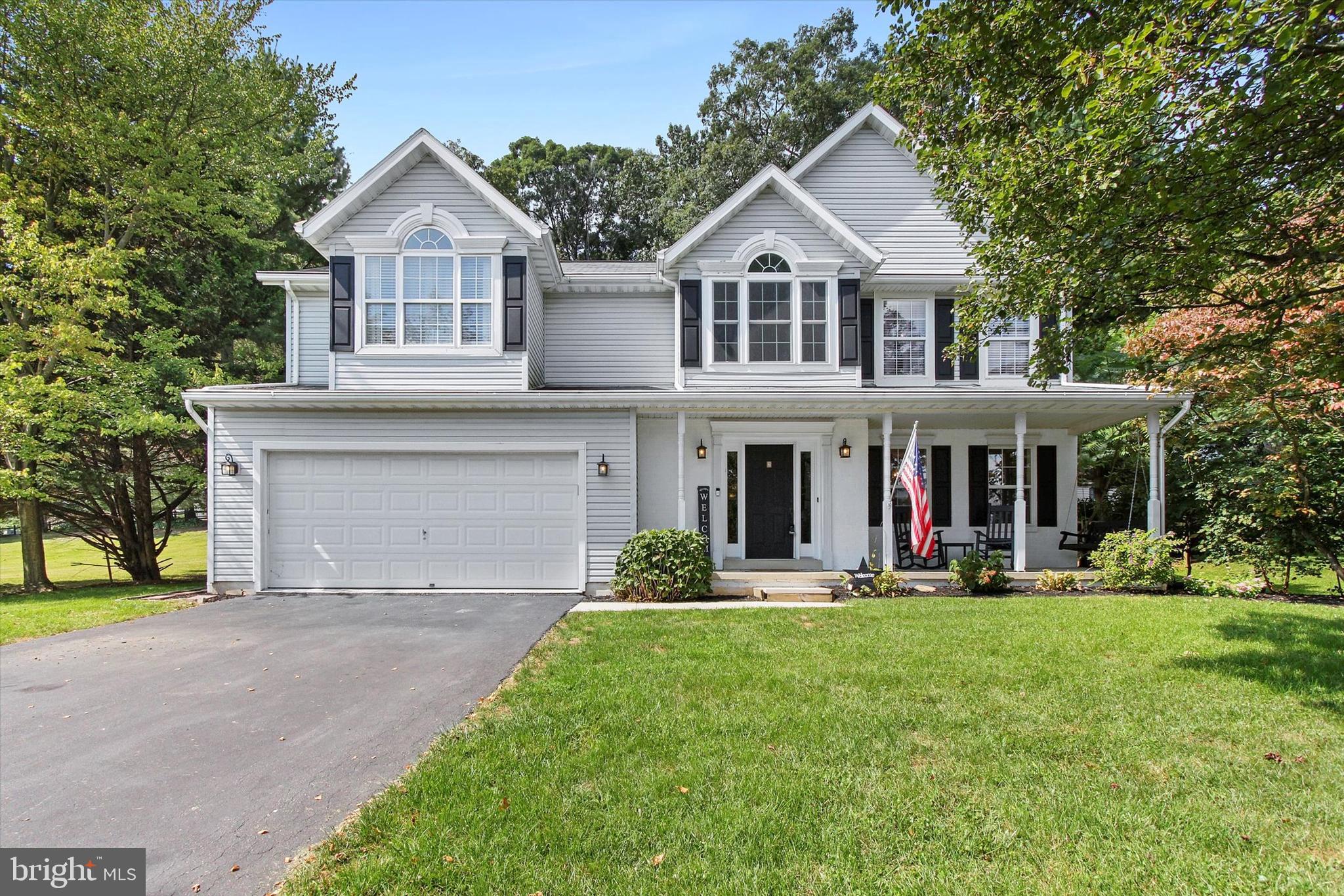 a front view of a house with a yard and trees