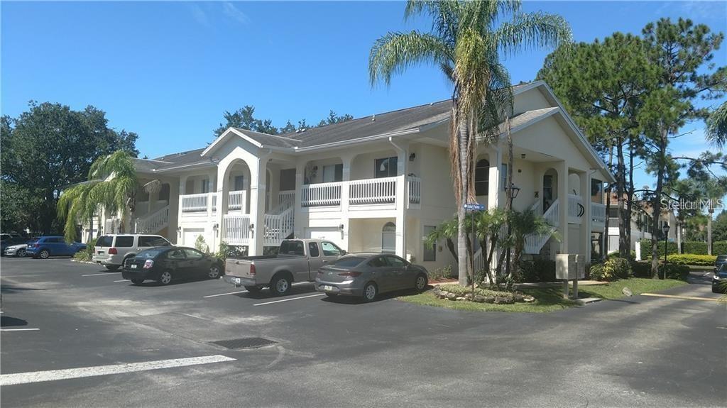 a view of a white house with a large windows and palm trees