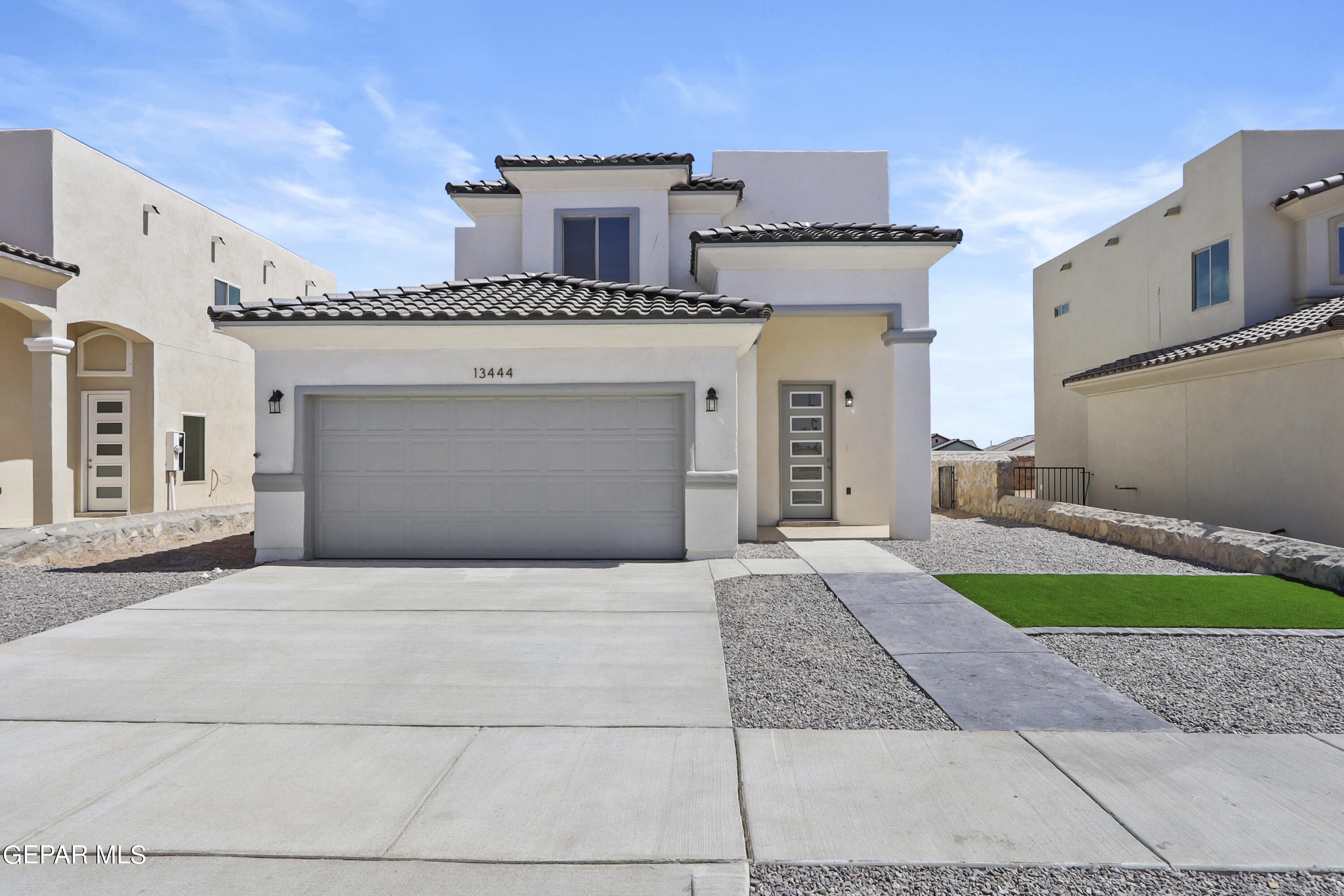 a front view of a house with a yard and garage