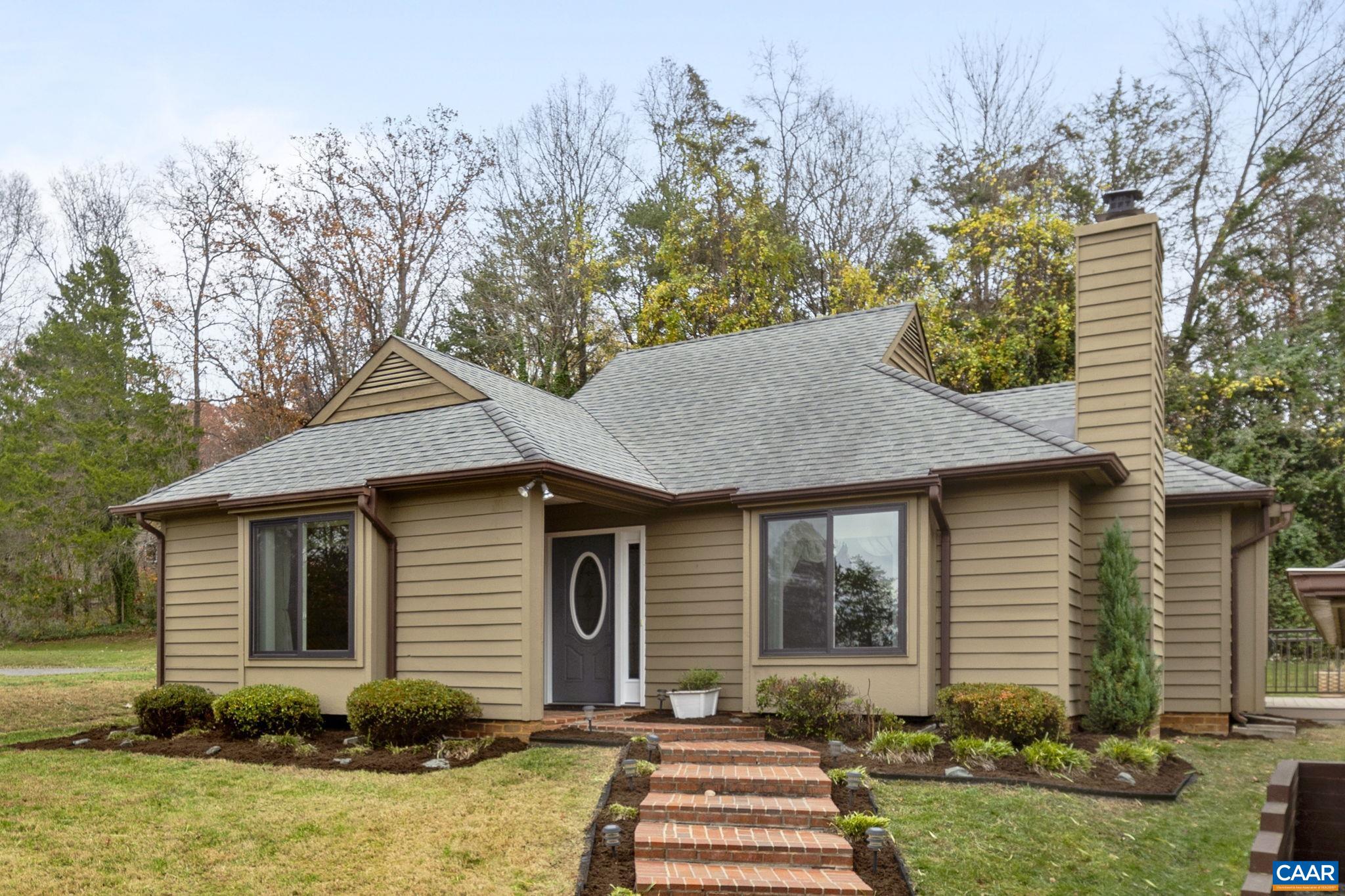 a front view of a house with a yard and trees