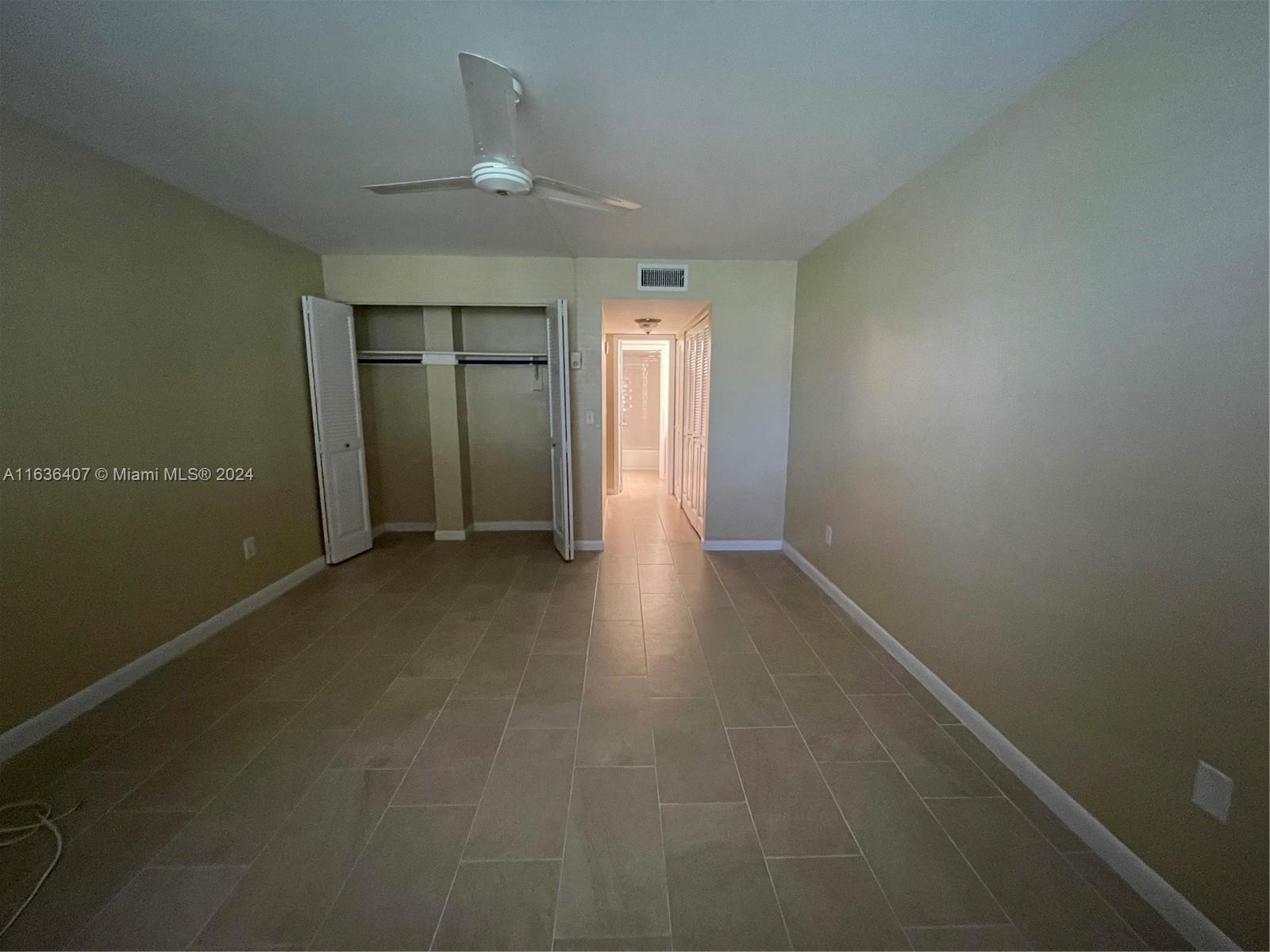 an empty room with closet and windows