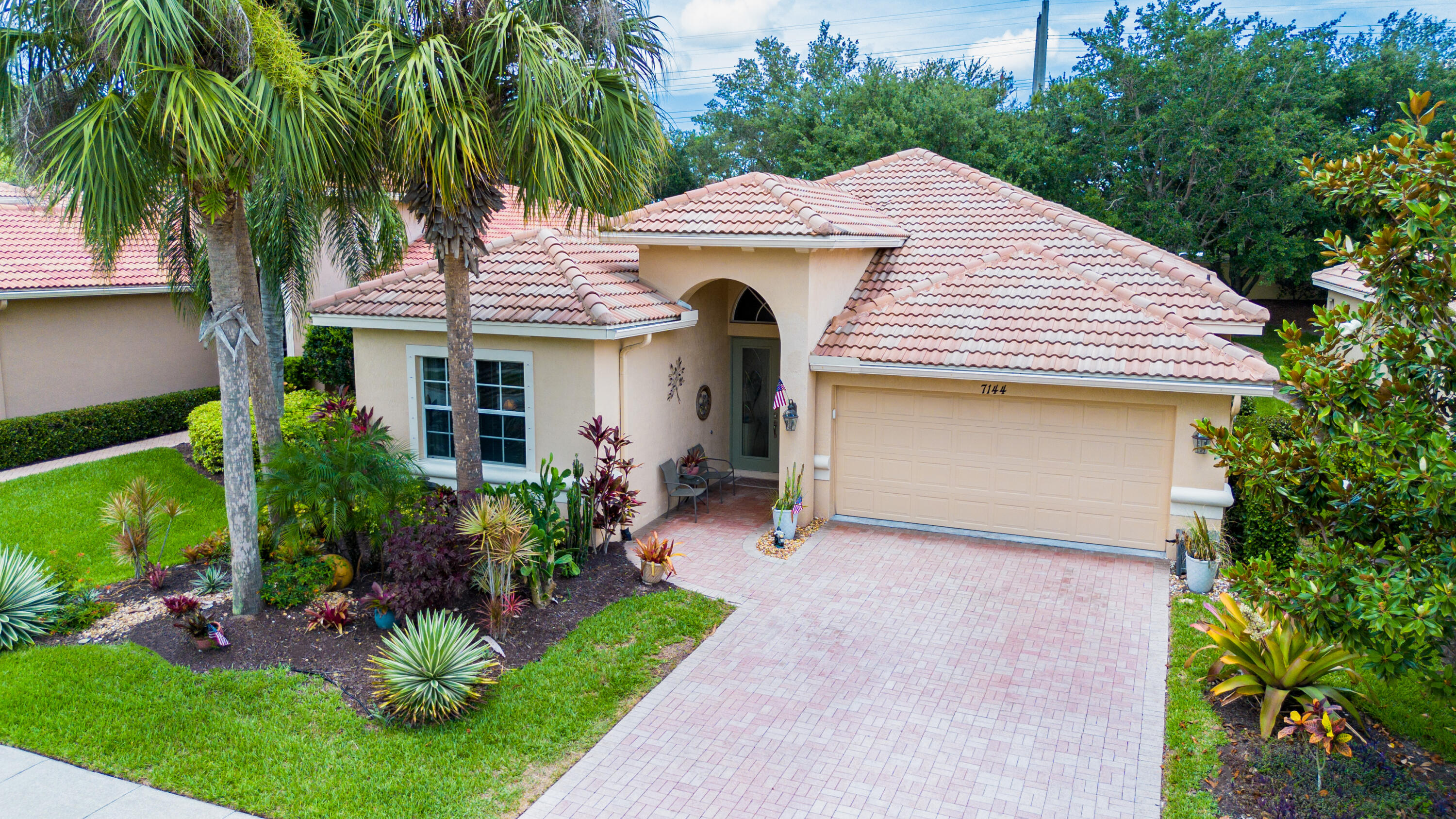 a front view of a house with a garden and plants