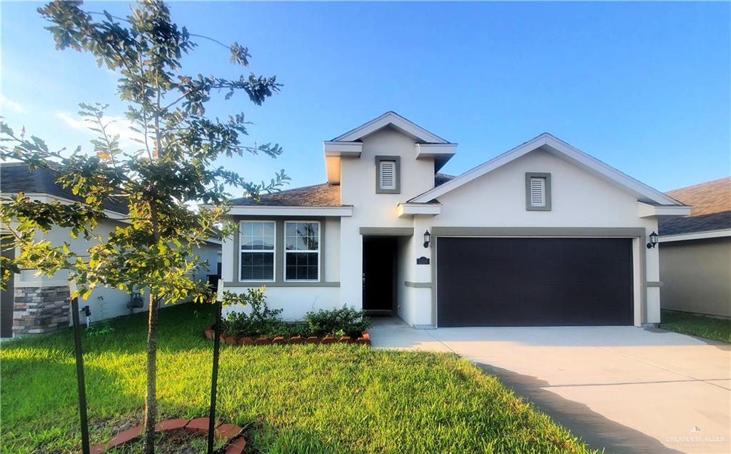 View of front of house featuring a front yard and a garage