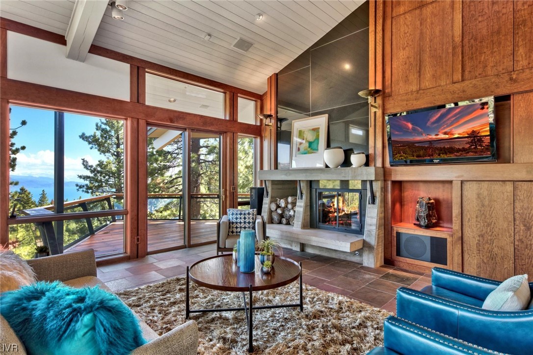 a living room with fireplace furniture and a floor to ceiling window