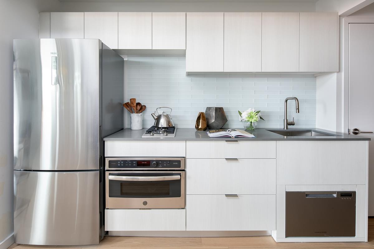 a kitchen with stainless steel appliances white cabinets and white appliances