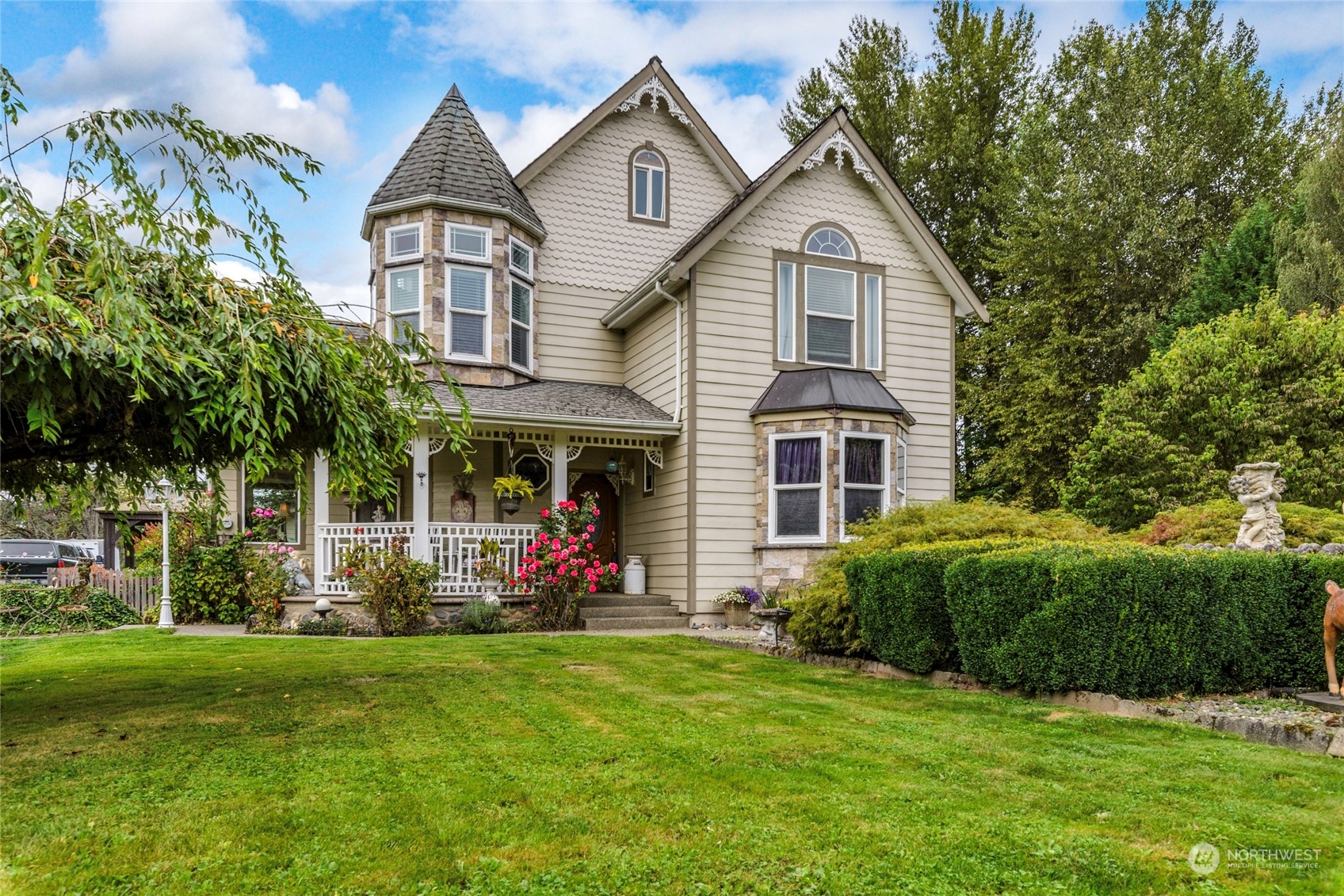 a front view of a house with a yard and potted plants